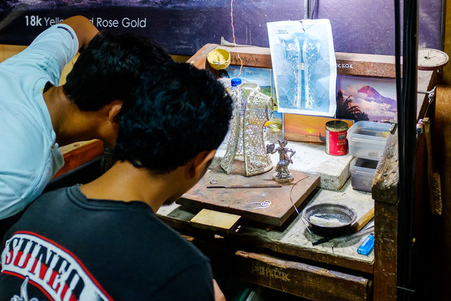 Workers creating a piece of silver art