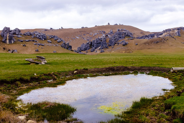 A small pond in front of the Castle Hill rock formation