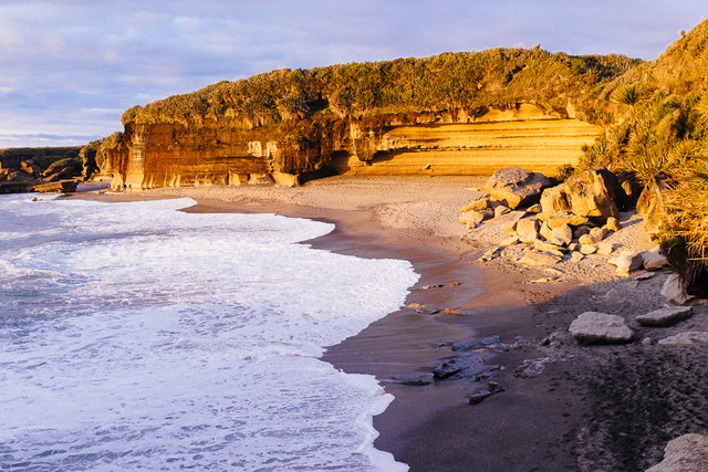 Rugged cliffs of limestone meet with the evening foam